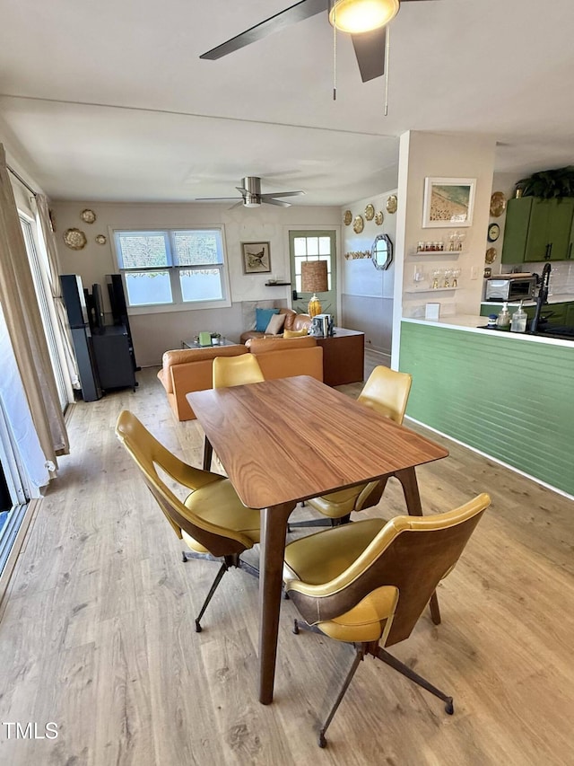 dining room featuring light wood-style floors, healthy amount of natural light, and ceiling fan