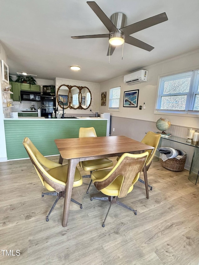 dining room featuring wood finished floors, a wall unit AC, and ceiling fan
