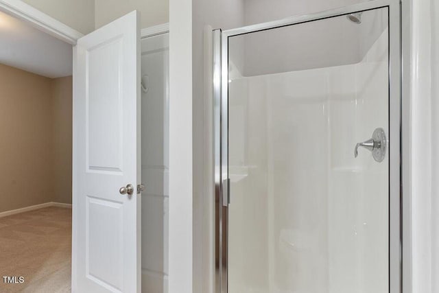bathroom featuring a stall shower and baseboards