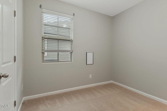 carpeted spare room featuring baseboards