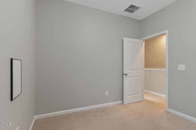 spare room with light colored carpet and baseboards