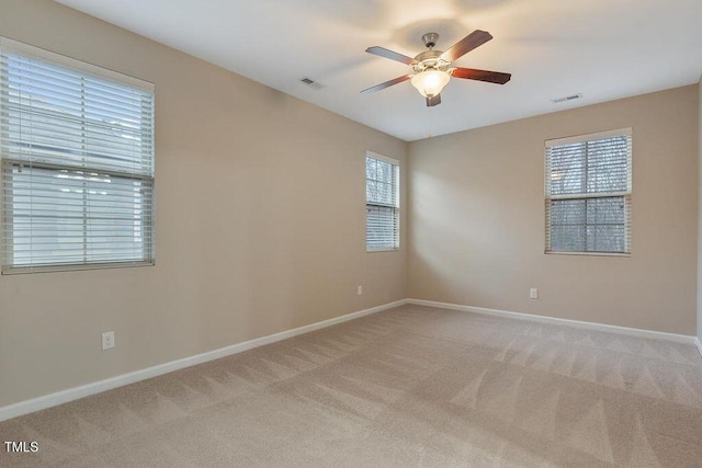 unfurnished room featuring a ceiling fan, light colored carpet, and baseboards
