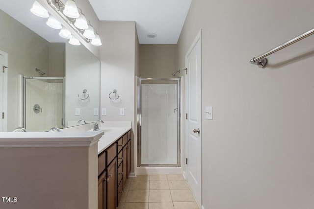 bathroom with a stall shower, tile patterned flooring, and vanity