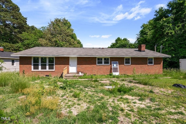 ranch-style home featuring brick siding, a chimney, and entry steps