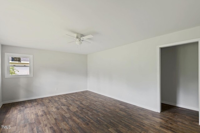 empty room featuring ceiling fan, dark wood-style flooring, and baseboards