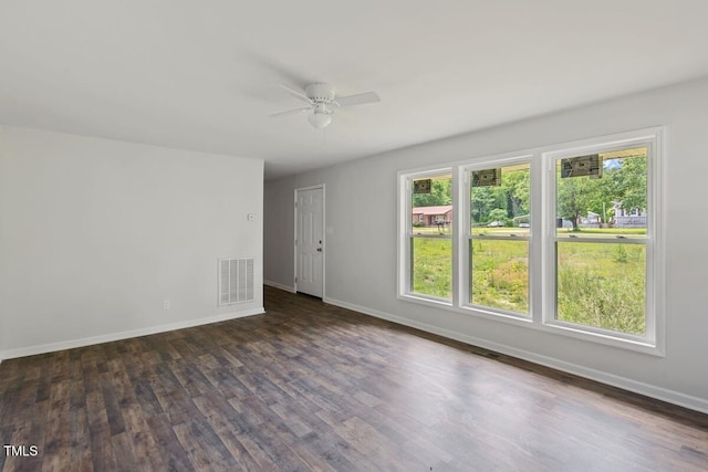 unfurnished room featuring ceiling fan, baseboards, and dark wood-type flooring