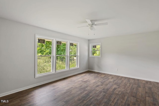 unfurnished room with baseboards, a ceiling fan, and dark wood-type flooring
