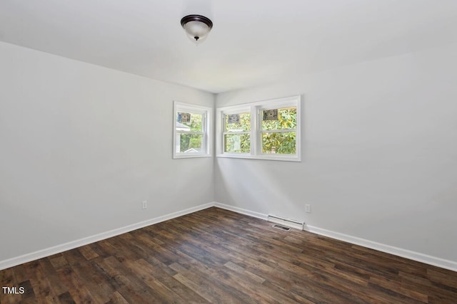 empty room featuring baseboards and dark wood-type flooring