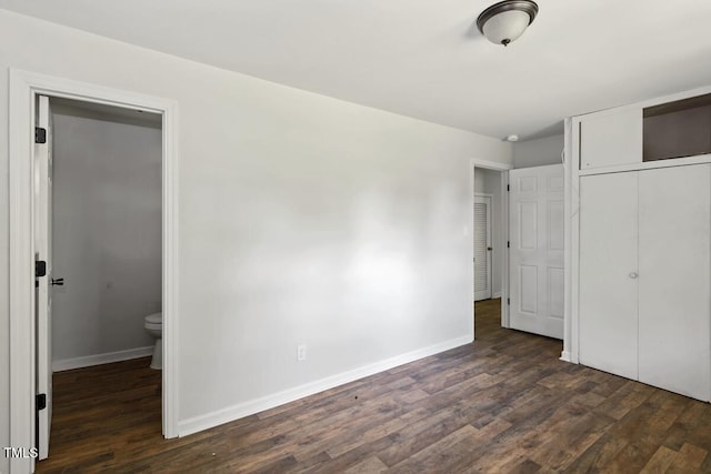 unfurnished bedroom featuring dark wood-style flooring, baseboards, and a closet