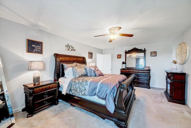 carpeted bedroom with a ceiling fan, baseboards, and a textured ceiling