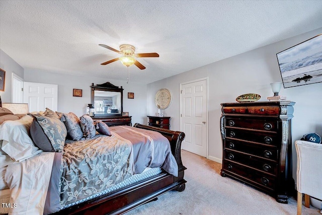 bedroom featuring light carpet, ceiling fan, and a textured ceiling