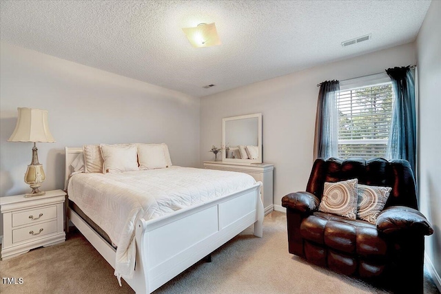 bedroom featuring light carpet and a textured ceiling