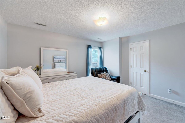 bedroom with carpet, a textured ceiling, and baseboards