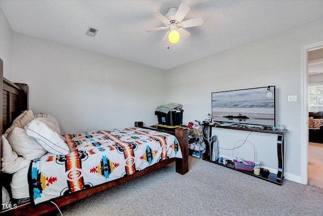 carpeted bedroom with a ceiling fan and a textured ceiling