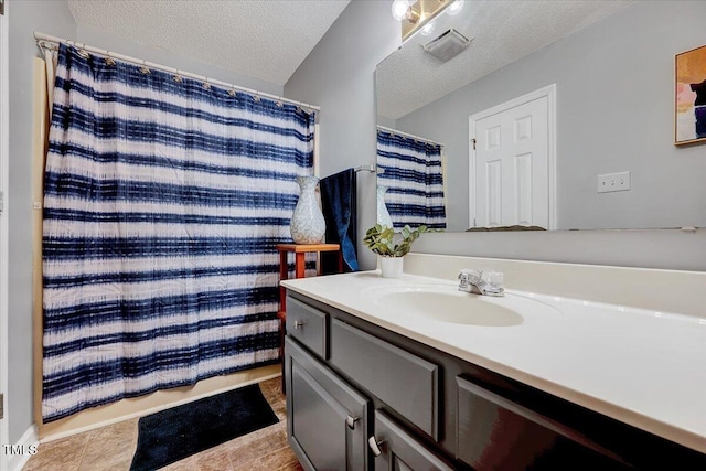 full bath with a textured ceiling and vanity