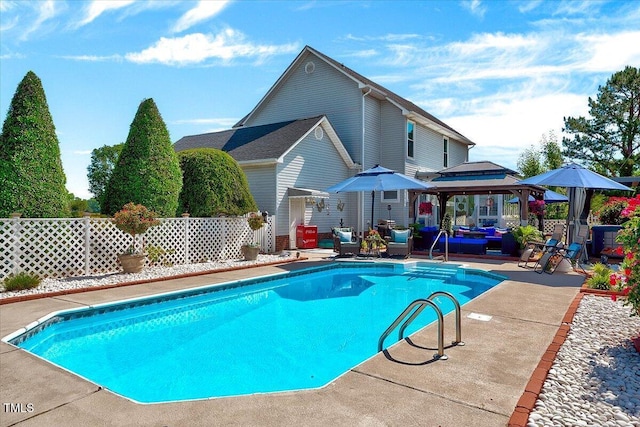 view of swimming pool featuring a gazebo, an outdoor living space, a patio area, and fence