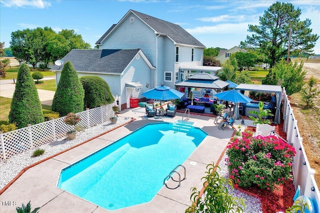 swimming pool with a gazebo, a patio, an outdoor hangout area, and a fenced backyard