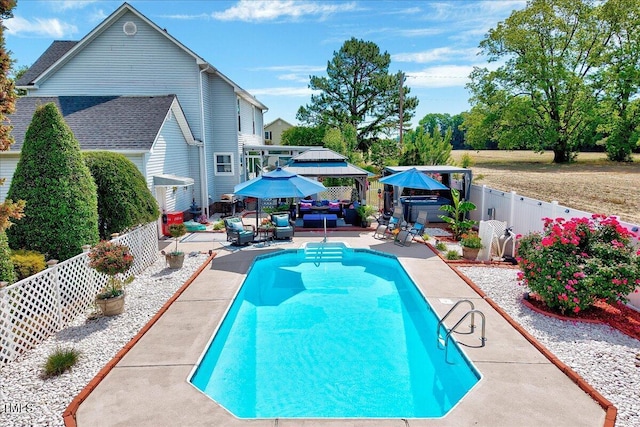 view of swimming pool with a gazebo, a fenced backyard, a patio area, and outdoor lounge area