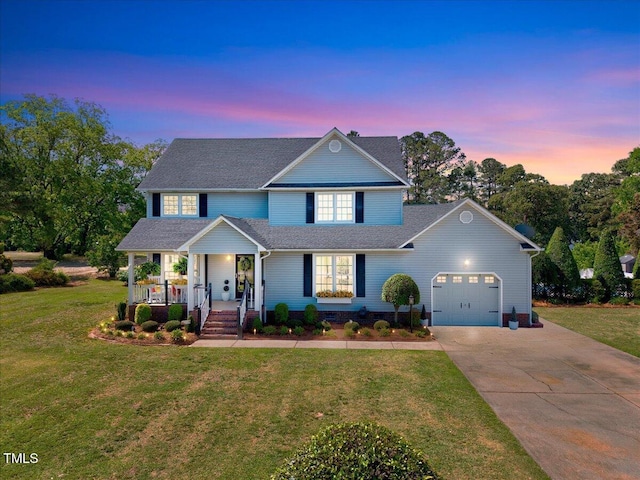 traditional-style home featuring a porch, an attached garage, concrete driveway, and a front yard