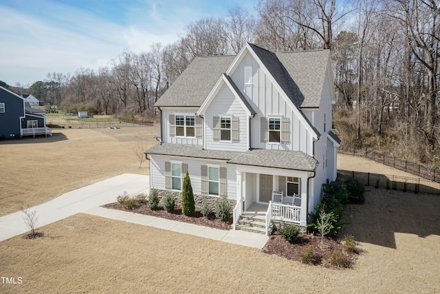 76 Freewill Pl, Raleigh, NC 27603 - view of front facade with covered porch, board and batten siding, roof with shingles, and fence