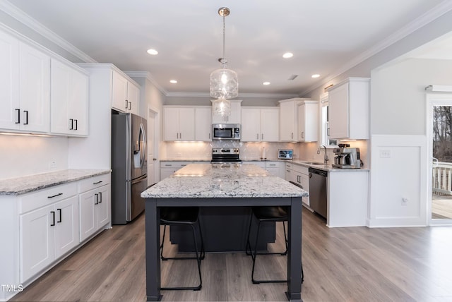 76 Freewill Pl, Raleigh, NC 27603 - kitchen featuring stainless steel appliances, a sink, a center island, white cabinetry, and light wood-style floors