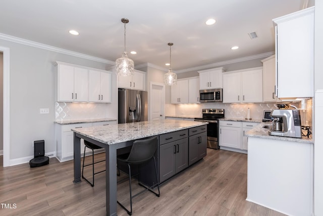 76 Freewill Pl, Raleigh, NC 27603 - kitchen featuring appliances with stainless steel finishes, a center island, white cabinetry, recessed lighting, and a breakfast bar