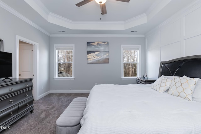 76 Freewill Pl, Raleigh, NC 27603 - bedroom with dark colored carpet, a tray ceiling, multiple windows, crown molding, and baseboards