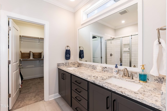 76 Freewill Pl, Raleigh, NC 27603 - bathroom featuring crown molding, a stall shower, a walk in closet, double vanity, and tile patterned floors
