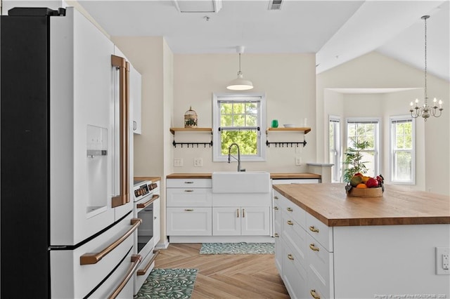 kitchen featuring white refrigerator with ice dispenser, a sink, wooden counters, open shelves, and stove