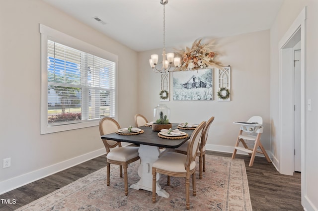 dining room with wood finished floors, a chandelier, and baseboards