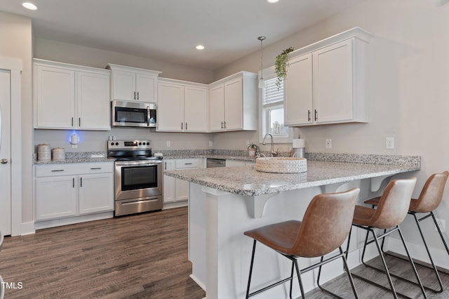 kitchen with stainless steel appliances, white cabinets, and recessed lighting