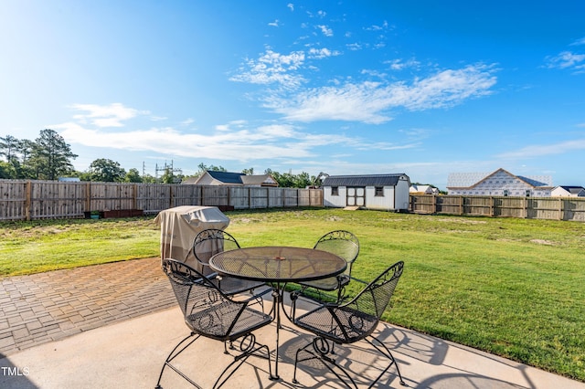 view of patio / terrace featuring a storage shed, an outdoor structure, and outdoor dining space