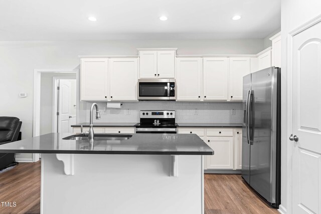 173 Longbow Dr, Middlesex, NC 27557 - kitchen featuring appliances with stainless steel finishes, a sink, dark countertops, dark wood finished floors, and recessed lighting