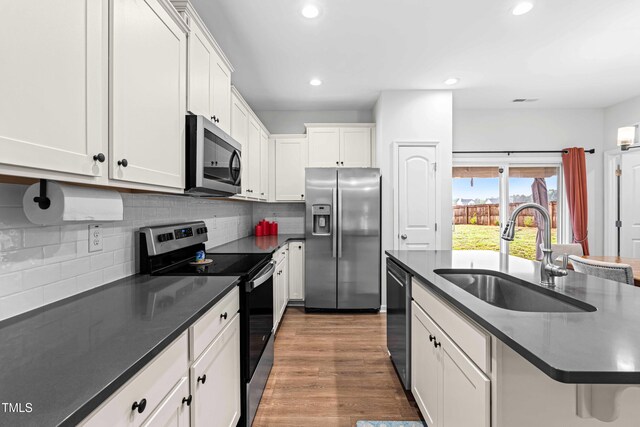 173 Longbow Dr, Middlesex, NC 27557 - kitchen featuring stainless steel appliances, a sink, dark countertops, decorative backsplash, and recessed lighting