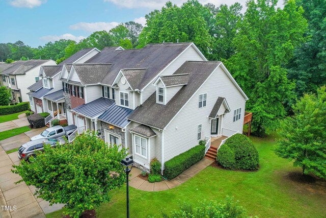 112 River Dell Townes Ave, Clayton, NC 27527 - view of front of property featuring a standing seam roof, a shingled roof, an attached garage, a front yard, and metal roof