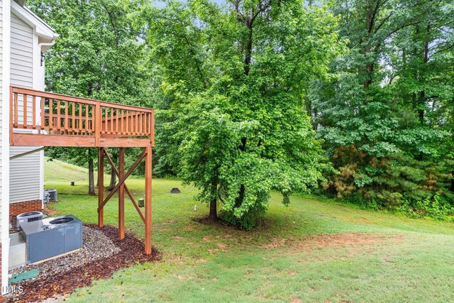 112 River Dell Townes Ave, Clayton, NC 27527 - view of grassy yard with a wooden deck, central AC unit, and view of wooded area