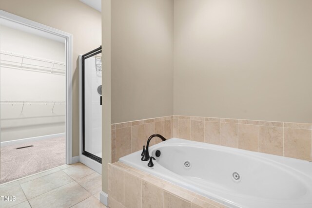 112 River Dell Townes Ave, Clayton, NC 27527 - bathroom with a shower stall, a tub with jets, a spacious closet, tile patterned floors, and baseboards