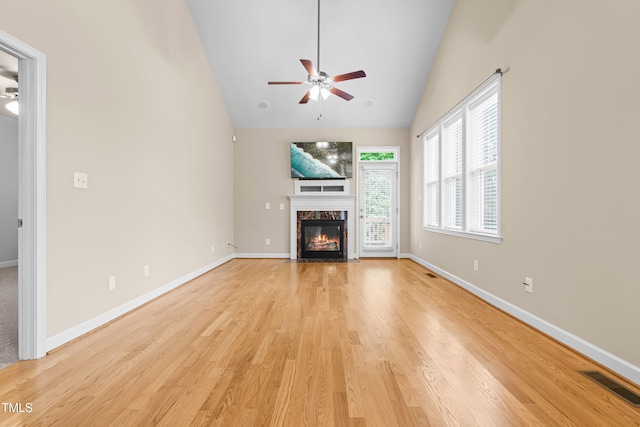 112 River Dell Townes Ave, Clayton, NC 27527 - unfurnished living room with ceiling fan, light wood finished floors, high vaulted ceiling, a fireplace, and baseboards