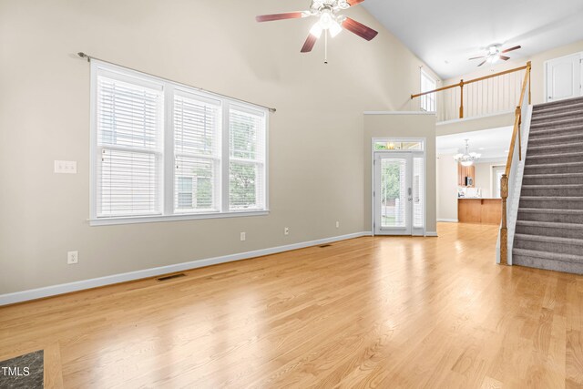112 River Dell Townes Ave, Clayton, NC 27527 - unfurnished living room with a ceiling fan, stairway, baseboards, and a high ceiling