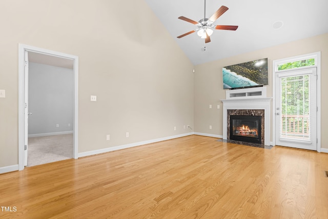 112 River Dell Townes Ave, Clayton, NC 27527 - unfurnished living room featuring a high end fireplace, high vaulted ceiling, ceiling fan, light wood-style floors, and baseboards
