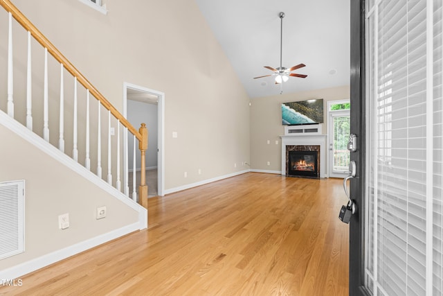 112 River Dell Townes Ave, Clayton, NC 27527 - unfurnished living room featuring ceiling fan, high vaulted ceiling, a premium fireplace, light wood-style flooring, and stairway