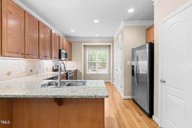 112 River Dell Townes Ave, Clayton, NC 27527 - kitchen with appliances with stainless steel finishes, light wood-style flooring, a peninsula, ornamental molding, and decorative backsplash