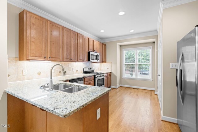 112 River Dell Townes Ave, Clayton, NC 27527 - kitchen with stainless steel appliances, a sink, baseboards, a peninsula, and light stone countertops