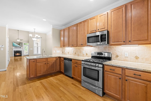 112 River Dell Townes Ave, Clayton, NC 27527 - kitchen featuring appliances with stainless steel finishes, a sink, a peninsula, light wood finished floors, and a chandelier