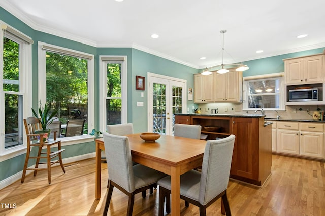 dining space with plenty of natural light, french doors, light wood finished floors, crown molding, and recessed lighting