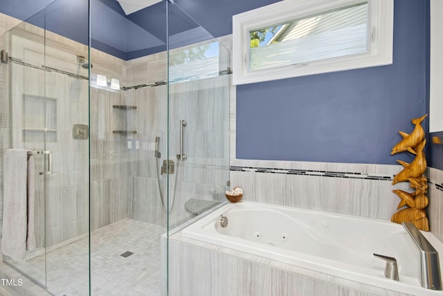 bathroom featuring a shower stall and a tub with jets