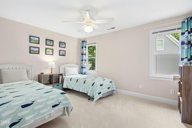 bedroom featuring carpet floors, multiple windows, baseboards, and a ceiling fan