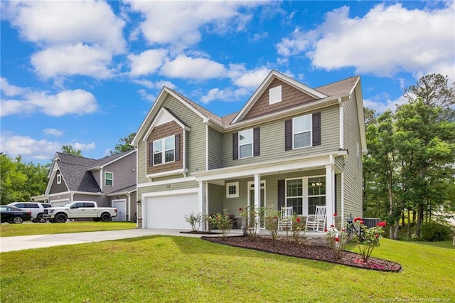 view of front of house with a porch, driveway, a garage, and a front lawn