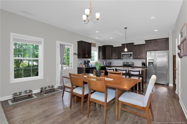 dining space with a chandelier, dark wood-type flooring, baseboards, and recessed lighting