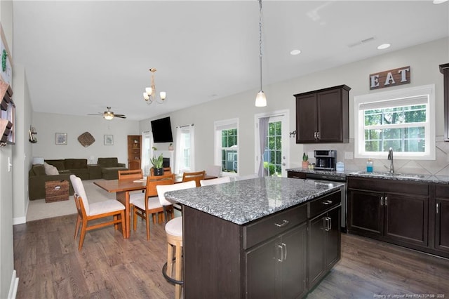 kitchen featuring a sink, plenty of natural light, a kitchen island, a chandelier, and recessed lighting